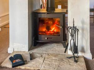 a stove in a living room with a fire at Chainbridge Cottage in Whitby