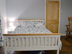 Una cama blanca con cabecero de madera en un dormitorio en Chestney House, en Hunstanton