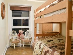 1 dormitorio con litera y sillas con osito de peluche en Chestney House, en Hunstanton 1 foto más