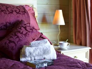 ein Bett mit Büchern und einer Lampe auf einem Tisch in der Unterkunft Hartland Forest Golf & Leisure in Woolfardisworthy