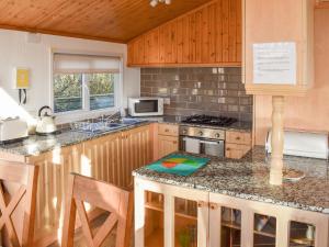 a kitchen with wooden cabinets and a counter top at Tranquillity in Millom