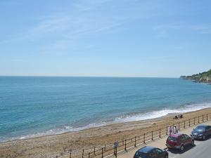 dos coches aparcados en una carretera junto a la playa en On The Beach, en Ventnor