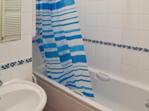 Un baño con lavabo y cortina de ducha. en On The Beach, en Ventnor