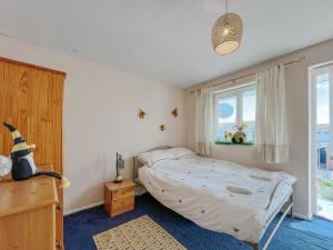 a bedroom with a bed and a large window at Little Orme Cottage in Penrhyn Bay