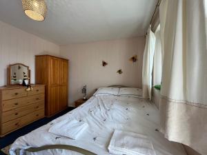 a bedroom with a large bed and a window at Little Orme Cottage in Penrhyn Bay +10 photos