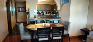 a kitchen with a table with chairs and a counter at Full apartment, with cinema in Riobamba
