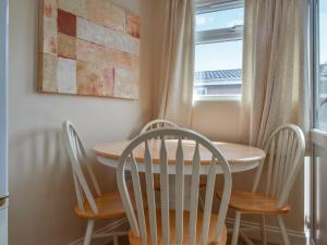 ein Esszimmer mit Tisch und Stühlen und einem Fenster in der Unterkunft Seven Bays Retreat in Padstow