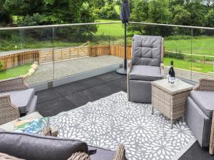 a patio with two chairs and a table and an umbrella at Y Felin in Llandissilio