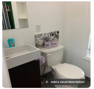 a bathroom with a white toilet and a sink at Hudson Guest House in Jersey City