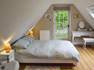 a bedroom with a bed and a sink and a window at The Coach House The Old Rectory in Buckland St Mary
