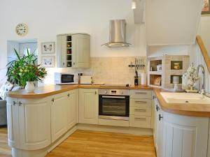 una cucina con mobili bianchi e un lavandino di Bridge Cottage a New Channelkirk Altre 7 foto