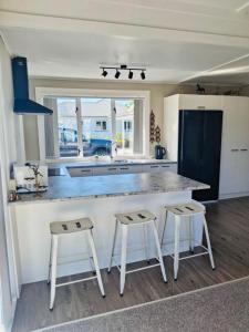 a kitchen with two stools and a large counter top at The cottage coghill in Whitianga