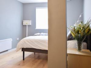 a bedroom with a bed and a vase of flowers at Apartment 1 - Uk50135 in Stoke on Trent +3 photos