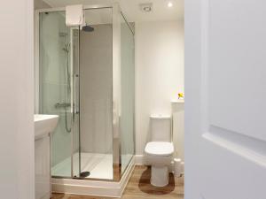 a bathroom with a toilet and a glass shower at Crested Grebe - Ukc2109 in Wroxham +4 photos