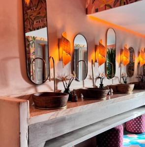 eine Reihe von Waschbecken in einem Badezimmer mit Spiegeln in der Unterkunft Riad Spa Medina Souks in Marrakesch + 9 Fotos