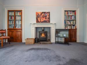 a living room with a fireplace and a tv at Escowbeck House in Lancaster