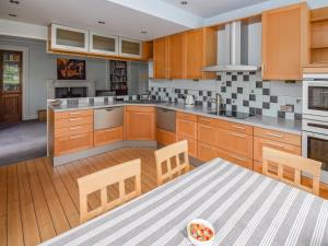 a kitchen with wooden cabinets and a table at Escowbeck House in Lancaster