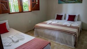 two beds in a room with towels on them at Pousada Plenamar in Maragogi +77 photos