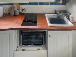 a kitchen with a stove top oven next to a sink at Lady V in Binton