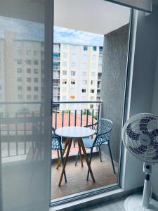 a patio with a table and chairs on a balcony at Apartamiento Ricaurte -Colombia in Girardot