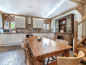 a large kitchen with a wooden table and chairs at Y Llaethdy - Uk49916 in Penclawdd
