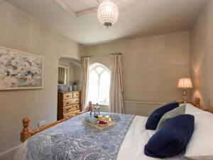a bedroom with a bed with a tray of food on it at Dell Cottage in Mundesley