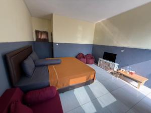 a bedroom with a bed and a couch and a television at Yuuhi Villa Glamping in Mancagahar