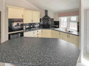 eine große Küche mit einer schwarzen Arbeitsplatte in der Unterkunft The Lodge in Chapel Saint Leonards