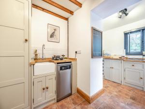a kitchen with white cabinets and a sink at Shire - Uk49791 in Cribyn
