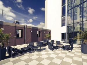 a patio with chairs and tables on a building at Mercure Cherbourg Centre Port in Cherbourg en Cotentin
