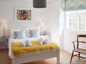 een slaapkamer met een bed met handdoeken op een gele deken bij 33 Chapel Street in Penzance