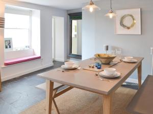 een eetkamer met een houten tafel met gerechten erop bij 33 Chapel Street in Penzance