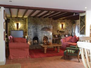 ein Wohnzimmer mit einer Steinmauer und einem Kamin in der Unterkunft Sardis Cottage in Stepaside