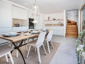 a kitchen and dining room with a wooden table and chairs at Y Bwthyn in Culbokie