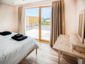 a bedroom with a bed and a sliding glass door at Y Bwthyn in Culbokie +8 photos