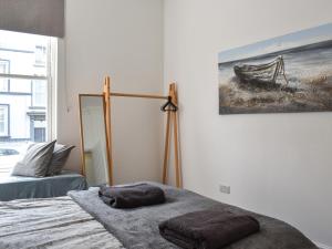 a bedroom with a bed and a lamp and a painting at Headland View in Scarborough