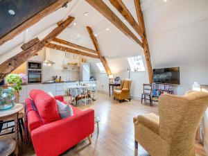 a living room with red chairs and a table at The Hay Loft in Durham
