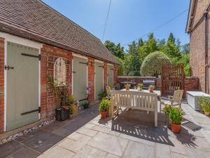 a patio with a bench and a table at The School House Cottage in Bradwell on Sea
