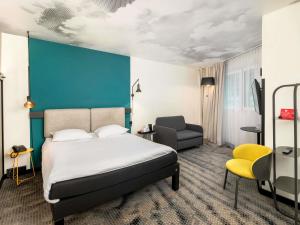 a hotel room with a bed and a chair at ibis Warszawa Centrum in Warsaw +82 photos