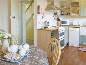a kitchen with a table with a vase on it at Tregatta Terrace in Tintagel