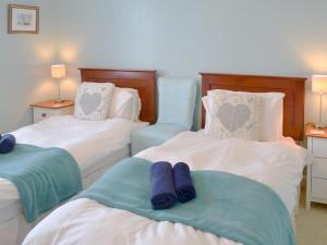 a bedroom with two beds with blue towels on them at Tregatta Terrace in Tintagel +8 photos