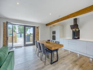 una cucina e una sala da pranzo con tavolo e sedie in legno di The Stone Barn 