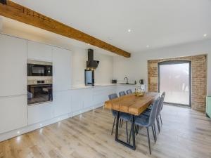 una cucina e una sala da pranzo con tavolo e sedie in legno di The Stone Barn 