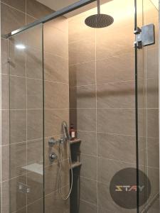 une douche avec une porte vitrée dans une salle de bain dans l'établissement Grand Medini Couple Stylish Netflix 100mbps BySTAY, à Nusajaya