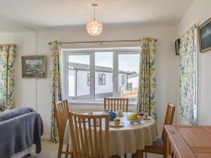 a dining room with a table and chairs and a window at 1 Merope in Padstow
