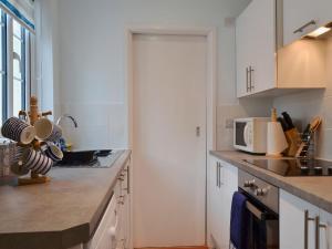 a kitchen with white cabinets and a counter top at Horseshoe Cottage in Porchfield