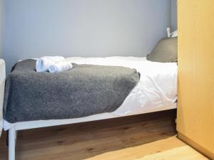 a bed with a gray blanket on top of it at Apartment 3 - Uk50137 in Stoke on Trent