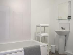 a white bathroom with a tub and a sink at Apartment 3 - Uk50137 in Stoke on Trent