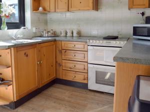 cocina con armarios de madera y horno de fogón blanco en Leanda Lodge, en Belton