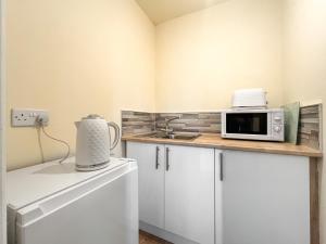 a small kitchen with a microwave on a counter at Denelea Studio 1 - Uk49952 in Scarborough